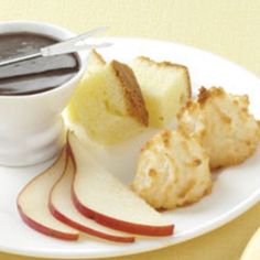 a white plate topped with slices of bread and apple slices next to a cup of chocolate sauce