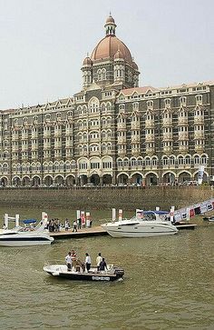 several boats in the water near a large building