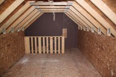 an attic with wooden walls and exposed rafters