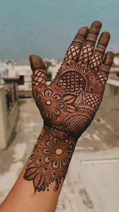 a hand with henna tattoos on it