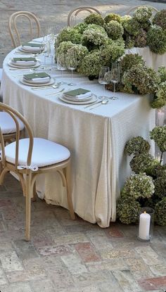 the table is set with white plates and silverware