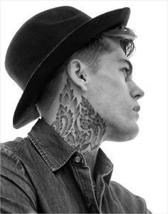 a man with a hat and tattoos on his neck