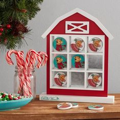 a christmas scene with candy canes, candies and an ornament on a table