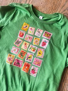 a child's green shirt with stamps on it