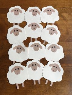 sheep cut out from white paper sitting on top of a wooden table with stickers