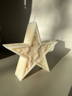 a white star shaped candle sitting on top of a table