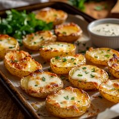 baked potatoes with cheese and parsley on a baking sheet, ready to be eaten