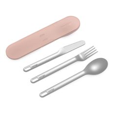 an assortment of utensils and spoons on a white surface with a pink handle