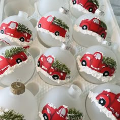 twelve christmas ornaments with red truck and pine tree decorations on them in an egg carton