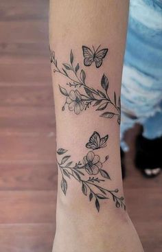 a woman's arm with butterflies and flowers on it