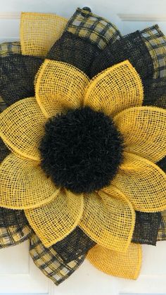 a yellow and black mesh flower on a white door