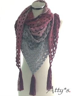 a white mannequin wearing a purple and gray scarf with tassels on it