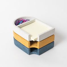 three pieces of concrete with different colors and shapes in them on a white table top