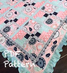 a pink and blue quilt on top of a wooden table