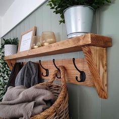 a wooden shelf with hooks on it next to a potted plant and other items