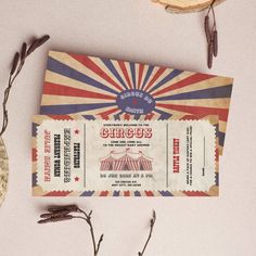 an old circus ticket sitting on top of a table next to dried flowers and leaves