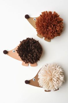 three hedgehogs made out of felt sitting next to each other on a white surface