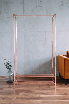 an orange chair sitting next to a metal rack on top of a hard wood floor