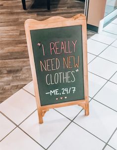 a sign on the floor that says i really need new clothes me 24 / 7