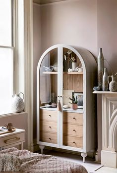 a bedroom with pink walls and white furniture