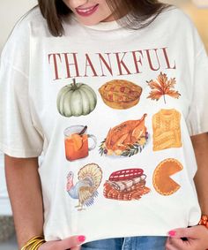 Introducing our "Thankful Thanksgiving Theme Graphic Shirt," a perfect addition to your festive fall wardrobe. Available in sizes S through 5XL, this shirt features the word "thankful" adorned with charming Thanksgiving-themed items such as a turkey, cozy blankets, delicious pie, pumpkin spice, warm sweaters, and autumn leaves.
Crafted from high-quality, soft materials, this shirt ensures all-day comfort, making it ideal for Thanksgiving gatherings, family feasts, or simply enjoying the autumn s Jesus Thanksgiving Shirts, Thanksgiving Collage, Thanksgiving Top, Disney Thanksgiving, Thanksgiving Clothes, Thankful Thanksgiving, Pie Pumpkin, Thanksgiving Theme, Family Feast