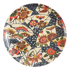 a decorative plate with flowers and leaves painted on the front, against a white background