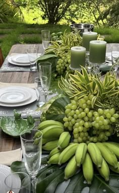 the table is set with green grapes and candles