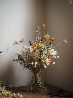 a bunch of flowers sitting on top of a wooden table