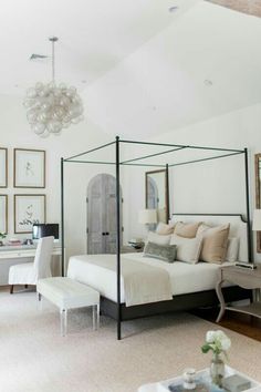 a bedroom with a four poster bed and pictures on the wall