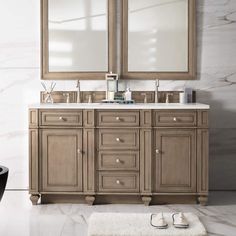 a bathroom vanity with two mirrors above it and a white rug on the floor next to it