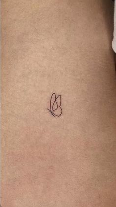 the back of a woman's stomach with a small heart tattoo on her left side