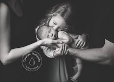 a black and white photo of a woman holding a baby in her arms with the caption's name on it