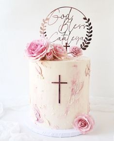 a white cake with pink flowers and a cross on top that says god is born