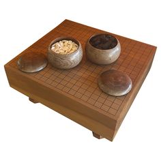 a wooden table topped with two bowls filled with different types of food on top of it