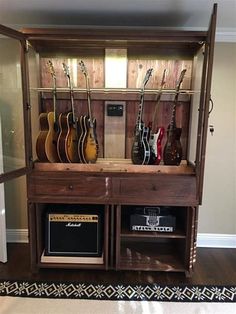 an entertainment center with guitars and amps in it