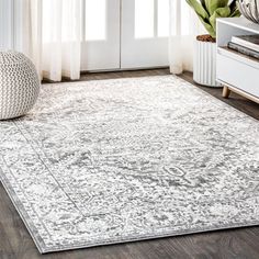 a white rug with an ornate design on the floor