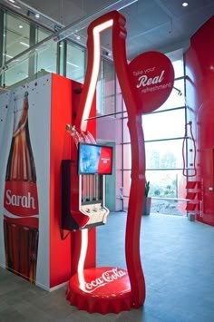 a coca - cola machine in the middle of a room