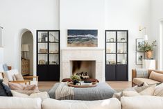 a living room filled with furniture and a fire place in the middle of a room