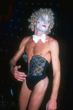 a man in a corset with white makeup on his face