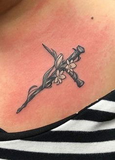 a cross tattoo with flowers on the chest