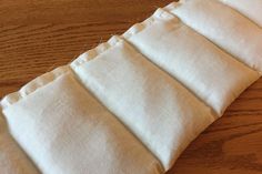 four pieces of white fabric sitting on top of a wooden table