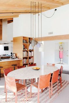 a dining room table with chairs and bookshelves in the background on a rug