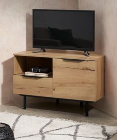 an entertainment center with a flat screen tv on it's stand, in front of a beige wall