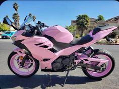 a pink motorcycle is parked on the street