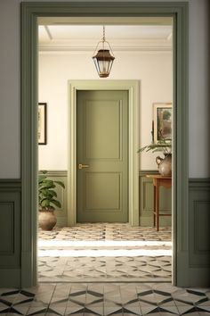 an open door leading into a room with tile flooring and green paint on the walls