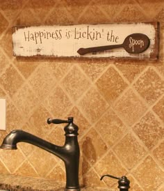 a bathroom sink with a sign above it that says happiness is lickin'the spoon