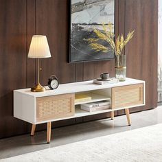 a living room scene with focus on the sideboard and lamp, which has a painting above it