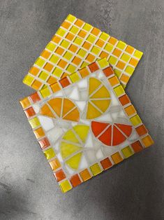 two pieces of colorful glass sitting on top of a table