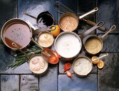 several pots and pans filled with different types of food on top of a tiled floor