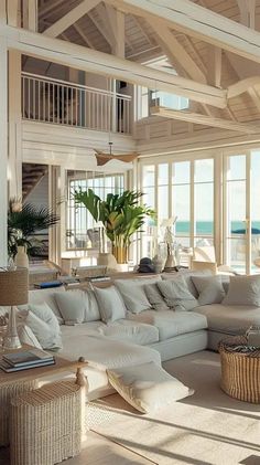 a large white couch sitting inside of a living room next to a tall wooden ceiling